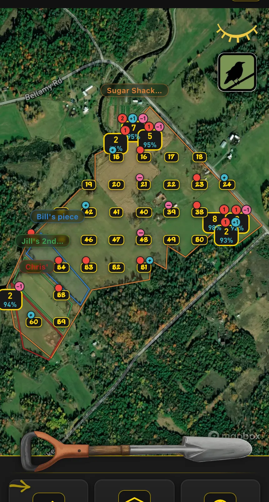 Several blocks outlined in orange, blue, green and red on satellite imagery, with a grid of numbered plot pins inside the largest